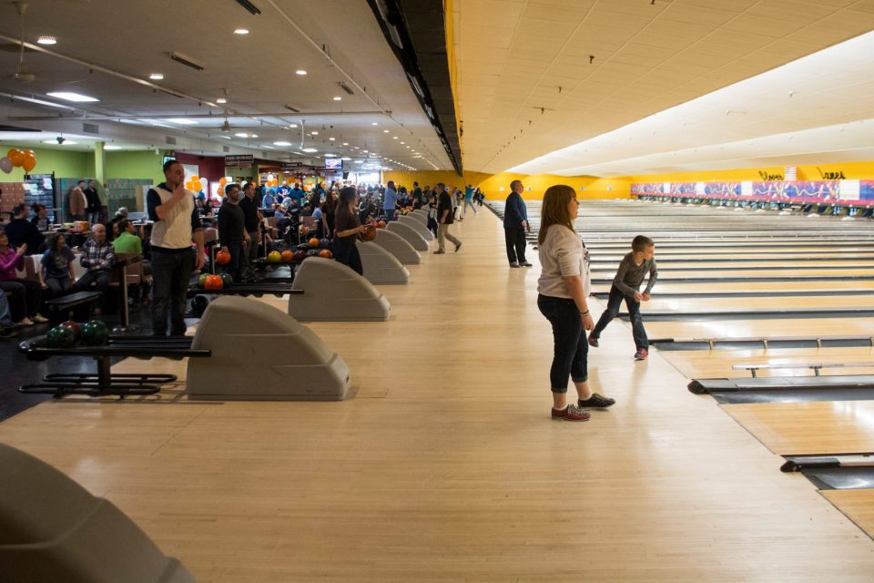 The bowling lanes with people bowling during the event