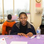 Young boy coloring at the autism awareness fair