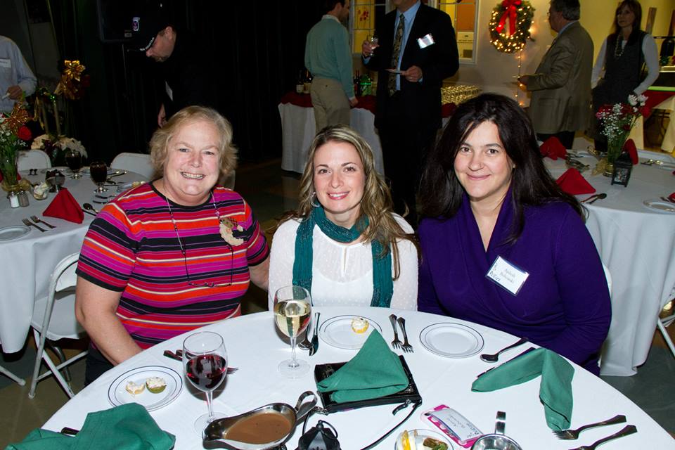 Three women sitting around a table smiling