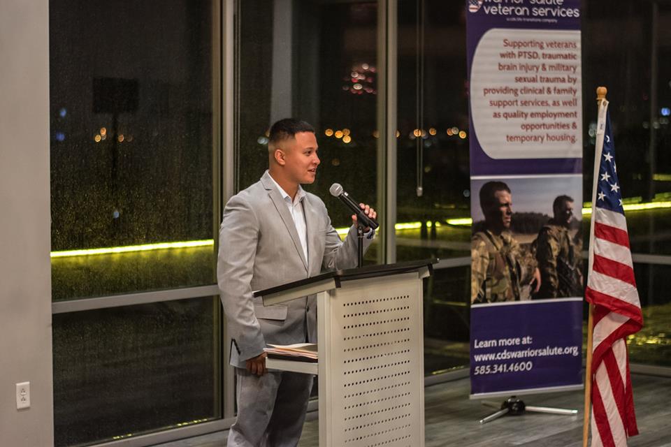 Speaker talking into a microphone at a podium at warrior salute dinner