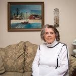 Older woman sitting in new housing unit